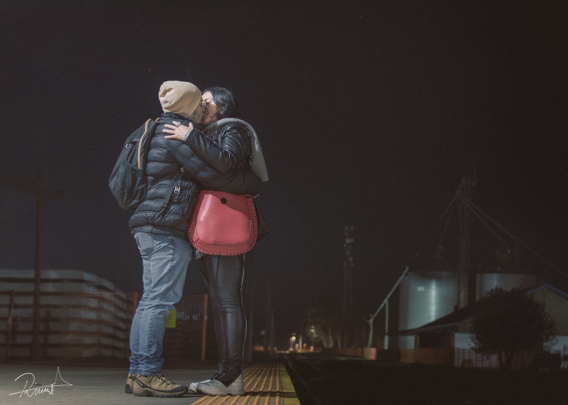 Dos personas abrazándose de noche en un espacio urbano